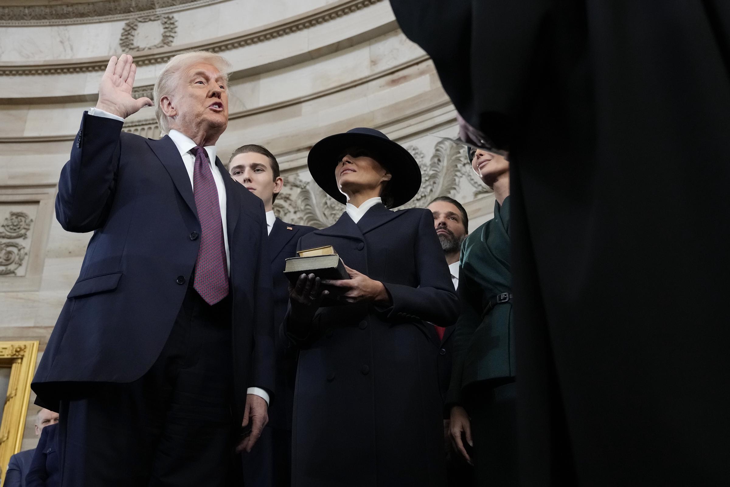 c90ee24d8a9729da39e15c93594f9f39a23b570768a864f36f7dd3ba902db479 Donald Trump taking an oath of office from Chief Justice John Roberts as Barron and Melania Trump look on. | Source: Getty Images